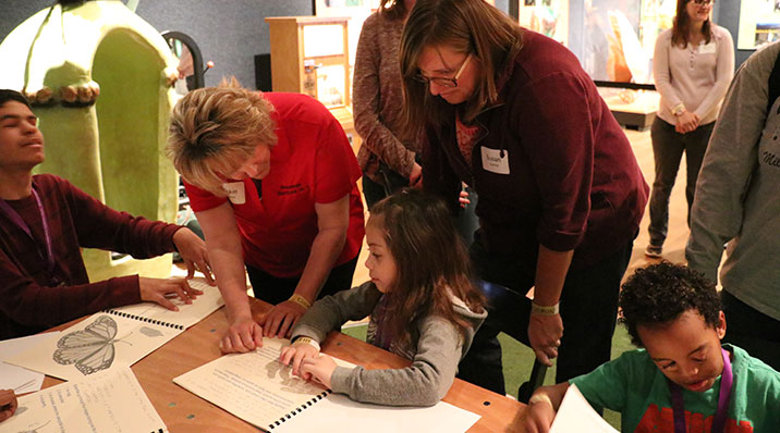 Blind role models from the community serve as mentors for young braille users, illustrating the use of braille in everyday life.